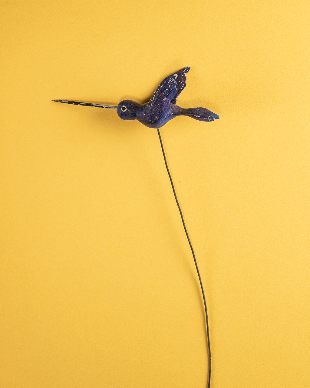 Bird on a wire on yellow by Jose Barrios