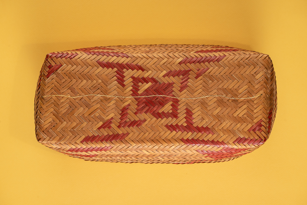 Woven basket on yellow by Jose Barrios